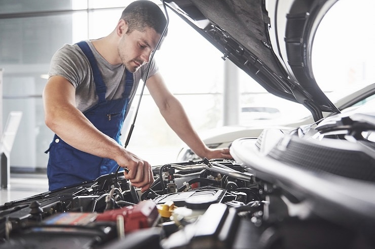 Mechanic working in garage and repair car